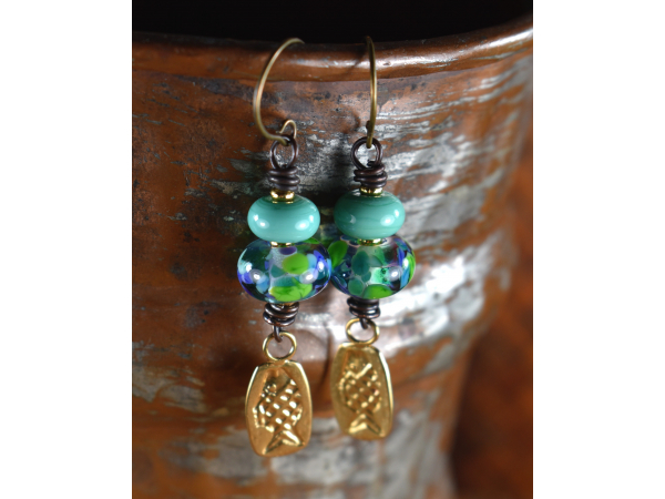 Blue and green lampwork glass with fish charms by Gloria Ewing.