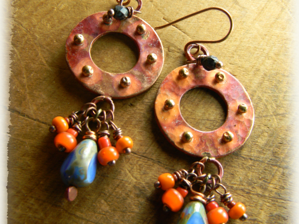 Orange patinaed copper hoop earrings by Gloria Ewing.