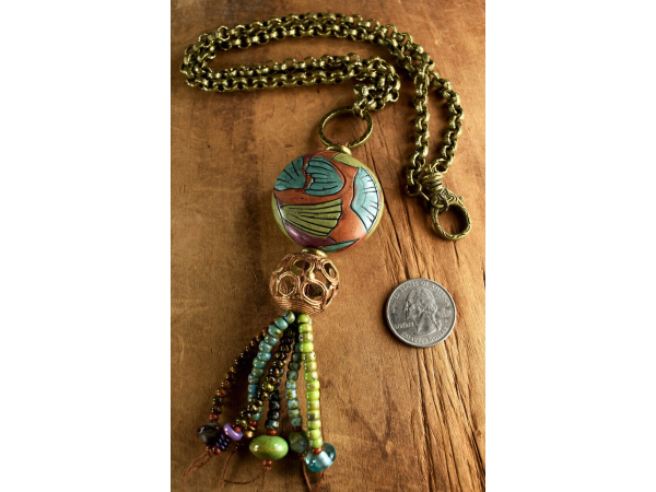 Colorful beaded tassel pendant with long chain by Gloria Ewing.
