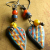 Ethnic style beaded earrings with orange white hearts by Gloria Ewing.