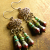 Delicate Bronze Chandelier Earrings Dark red and blue with bronze in beaded earrings by Gloria Ewing.