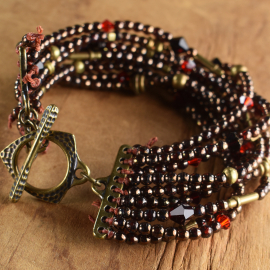 Garnet Czech Glass Beaded Bracelet Nine strand beaded bracelet with brass from Gloria Ewing.
