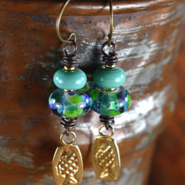 Blue and green lampwork glass with fish charms by Gloria Ewing.