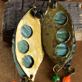 Layered metal with cut outs and African dangles by Gloria Ewing.