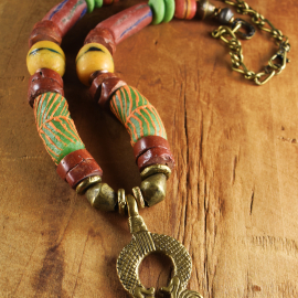 Bright colored Krobo beads with brass pendant, design by Gloria Ewing.